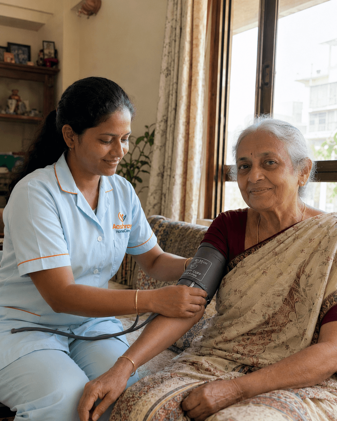 An Aashray nurse checking an elderly woman's blood pressure at home in Mumbai
